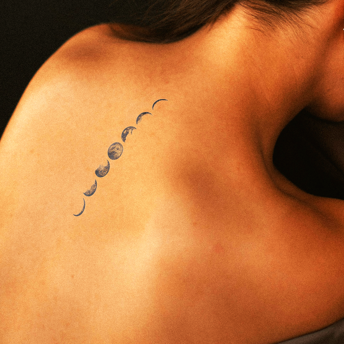 Tattoo of moon phases on a person's shoulder