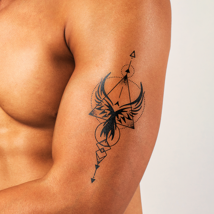 Tattoo of a phoenix on a person's arm with a plain background